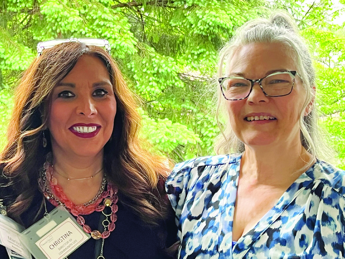 Two women next to each other smiling at the viewer.