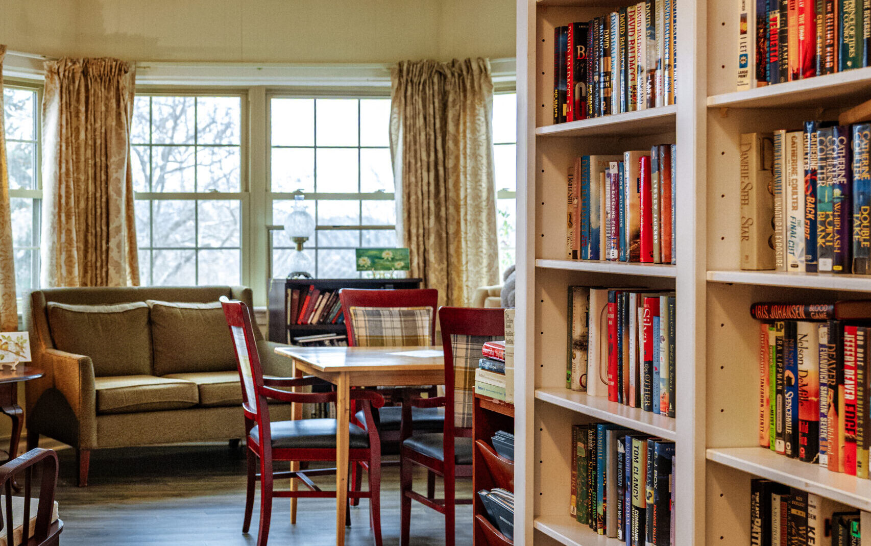 room with table and bookshelf full of books